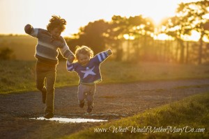 two young borthers holding hands and jumping over a puddle at sunset